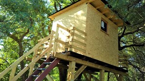 A wooden treehouse with a small window, built on a sturdy wooden platform with a ladder leading up. - Luxury 200m² villa with private pool, Clevacances label (3 keys) (Saint-Clément)