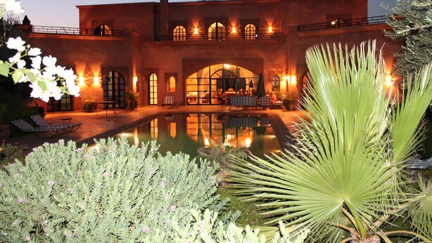 A large building with a pool, outdoor seating, and a well-lit entrance. - Marrakech Villa for 6-16 people - Exclusive Offer - 450 sq.m and 16 x 5.5 m pool (Marrakech)