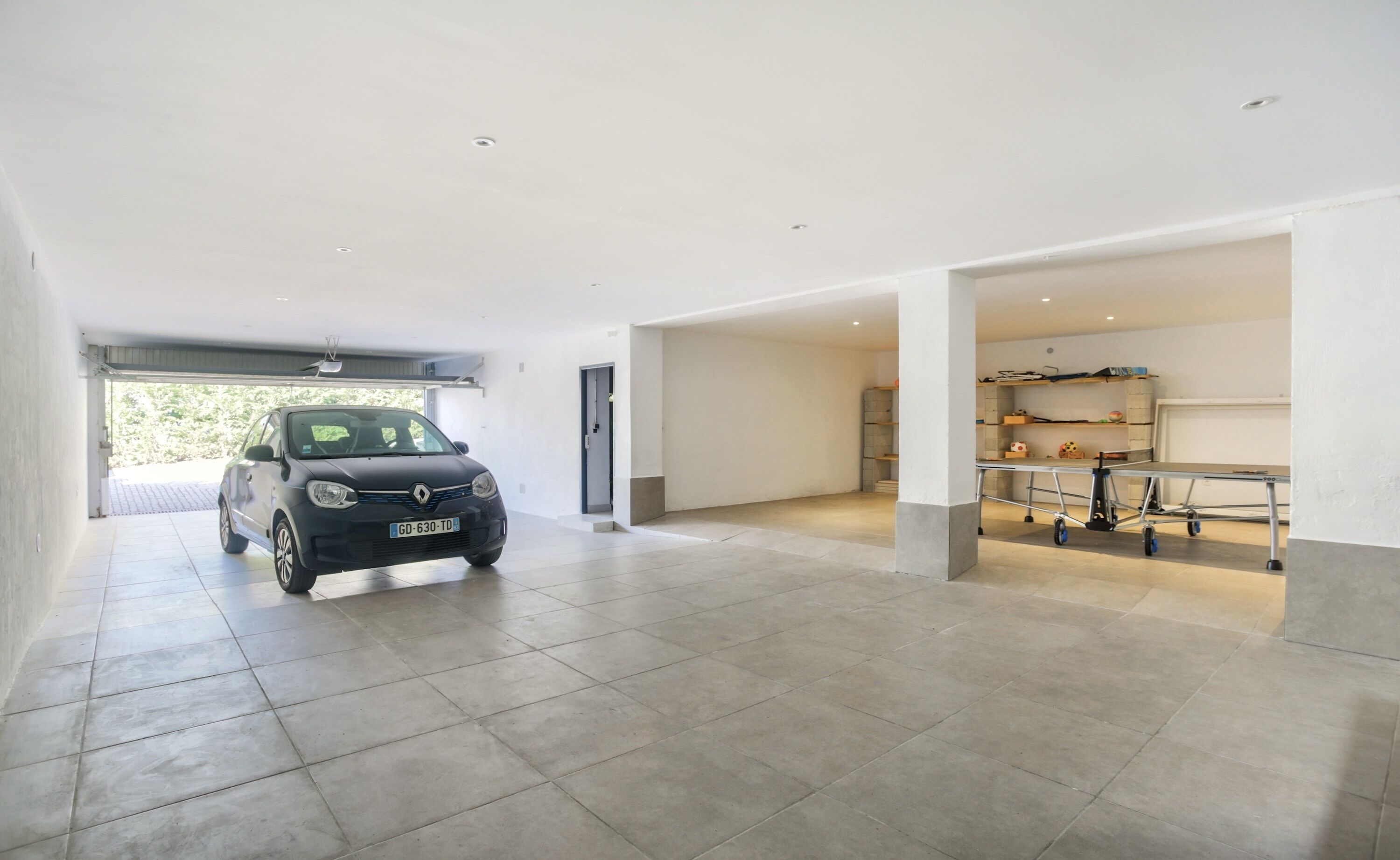 A spacious garage with a car parked inside.