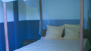 A four-poster bed with a canopy, wooden headboard, and two bedside tables. - between the sea and the Caribbean sun garden (Trinité)
