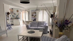 A modern living room with a sofa, a coffee table, and a dining area with a table and chairs.