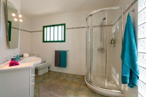 A bathroom with a shower, sink, and toilet.