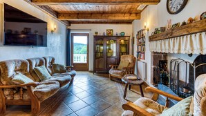 Una sala de estar acogedora con chimenea, muebles de madera y un reloj grande en la pared.