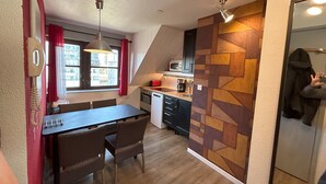 Una cocina compacta con comedor, microondas y cafetera.