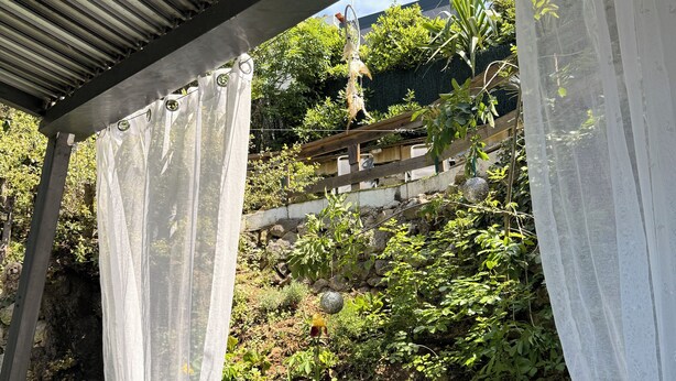An outdoor hot tub area with a metal roof and white curtains. - Detached house with summer Jacuzzi (May to early October), barbecue. (Nice)