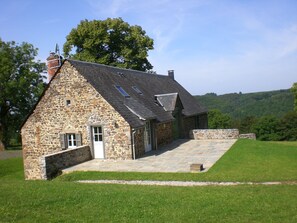 A stone house with a sloped roof, a small porch, and a door with windows. - Large **** farmhouse renovated in the countryside. (Larodde)