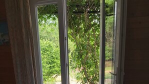Una camera da letto con un letto, una finestra e vista su un giardino.