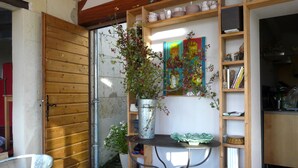 Une cuisine avec des étagères en bois, une plante en pot et un tableau.