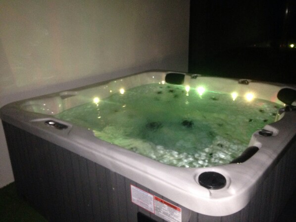 Un jacuzzi con una etiqueta en el lateral, rodeado de un ambiente oscuro.