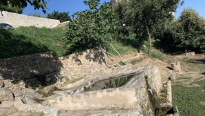 An ancient stone structure with a partially intact wall and a small opening. - LUXURY VILLA with exceptional panoramic views, a pool, and ocean views (Speloncato)
