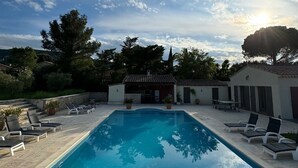 A rectangular swimming pool with lounge chairs and a pergola, surrounded by a landscaped area with trees and a building in the background. - 2 DUPLEX   1 STUDIO IN A WONDERFUL AND PEACEFUL PLACE (Maubec)