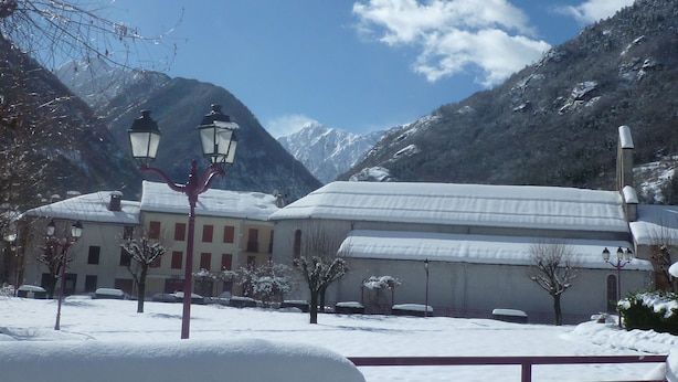 Ein Gebäude mit verschneitem Dach und Bergblick.