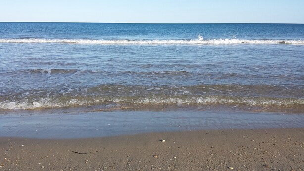 A beach with waves gently lapping onto the shore.