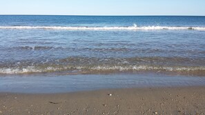 Une plage où les vagues viennent doucement lécher le rivage.