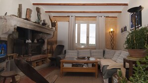 Ein gemütliches Wohnzimmer mit Kamin, einer Couch, einem Couchtisch und einem Bücherregal.