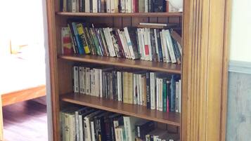 A wooden bookcase with multiple shelves filled with books.