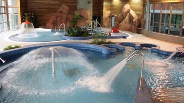 An indoor swimming pool with multiple water features and a natural rock wall backdrop. - APARTMENT T2 DOWNTOWN IDEAL CURES SKI RIDE FREE WIFI (Mont-Dore)