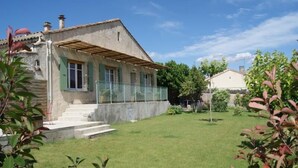 A house with a small front yard, a wooden pergola, and a stone wall. - 5 minutes from the ochre mines Gîte la Charité next to Gordes Roussillon (Gargas)