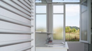 A bathroom with a window, a sink, and a towel rack. - 5 minutes from the ochre mines Gîte la Charité next to Gordes Roussillon (Gargas)