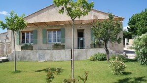 A two-story house with a balcony, a small garden, and a clear blue sky. - 5 minutes from the ochre mines Gîte la Charité next to Gordes Roussillon (Gargas)