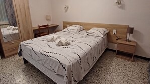 A bedroom with a bed, nightstands, a mirror, and a chandelier. - 5 minutes from the ochre mines Gîte la Charité next to Gordes Roussillon (Gargas)