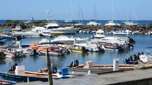 A marina with various boats docked, including sailboats and motorboats. - House (Deshaies)