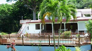 A house with a pool, a covered patio, and a staircase leading to a balcony. - House (Deshaies)