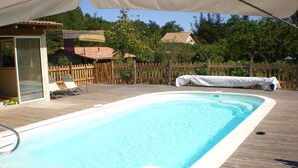Una piscina rettangolare circondata da un pontile in legno.