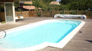 Een buitenzwembad en ligstoelen