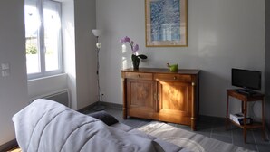A room with a bed, a wooden cabinet, a TV, and a painting on the wall. - Charming country house (Andonville)