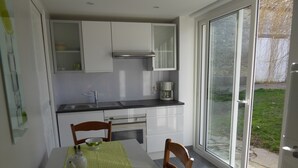 A compact kitchen with a dining table, chairs, and a coffee maker. - Charming country house (Andonville)