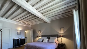 Una camera da letto con un letto grande, una cassettiera, un armadio e una porta che dà su un'altra stanza.
