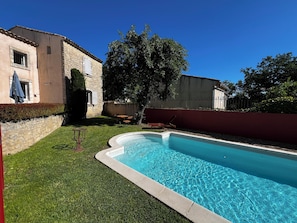 Une piscine avec un bâtiment en pierre en arrière-plan.