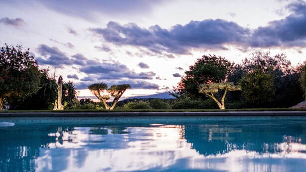 A swimming pool with clear water reflecting trees and a cloudy sky. - Villa Angel - Panoramic view with magnificent swimming pool and pool house (La Gaude)
