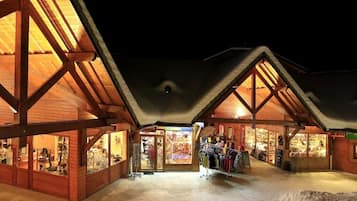 A wooden building with large windows and a snow-covered ground.