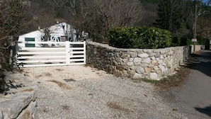 A gravel driveway leading to a white gate with a stone wall and a green bush. - HOUSE IN THE HEART OF THE VALLEYS CEVENOLES large pool access (Chambon)
