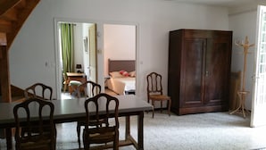 A room with a dining table, chairs, a wardrobe, and a bed with a nightstand. - HOUSE IN THE HEART OF THE VALLEYS CEVENOLES large pool access (Chambon)