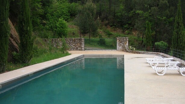 A swimming pool with a stone wall and a metal fence. - HOUSE IN THE HEART OF THE VALLEYS CEVENOLES large pool access (Chambon)