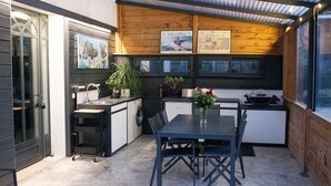 Una cocina moderna con zona de comedor, que incluye un horno empotrado, un lavamanos y una mesa con sillas.