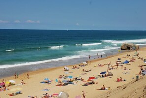 A crowded beach with people sunbathing and swimming, a large rock formation, and the ocean in the background. - Villa 600 m from the beach, heated swimming pool 9x4, classified 3*. (Labenne)