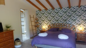 A bedroom with a bed, wooden headboard, and a wall with a leaf pattern. - Villa 600 m from the beach, heated swimming pool 9x4, classified 3*. (Labenne)