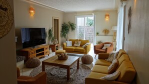 A living room with a TV, sofas, a coffee table, and decorative items. - Villa 600 m from the beach, heated swimming pool 9x4, classified 3*. (Labenne)