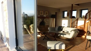 Ein geräumiger Wohnbereich mit Kamin, einer Couch, einem Couchtisch und einem Esstisch.