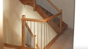 Eine Holztreppe mit Glasgeländern und einem Metallhandlauf.