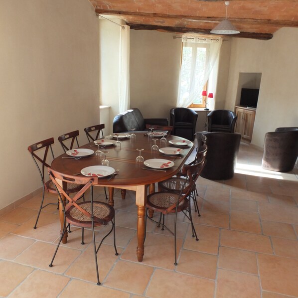 Un coin repas avec une table ronde dressée pour six personnes, entourée de six chaises.