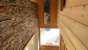Un intérieur en bois avec un mur en pierre, une poutre en bois au plafond et une fenêtre.