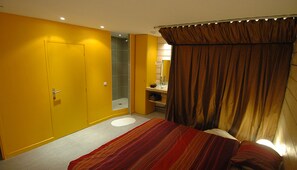 Ein Schlafzimmer mit Bett, ein Badezimmer mit Dusche und Toilette.