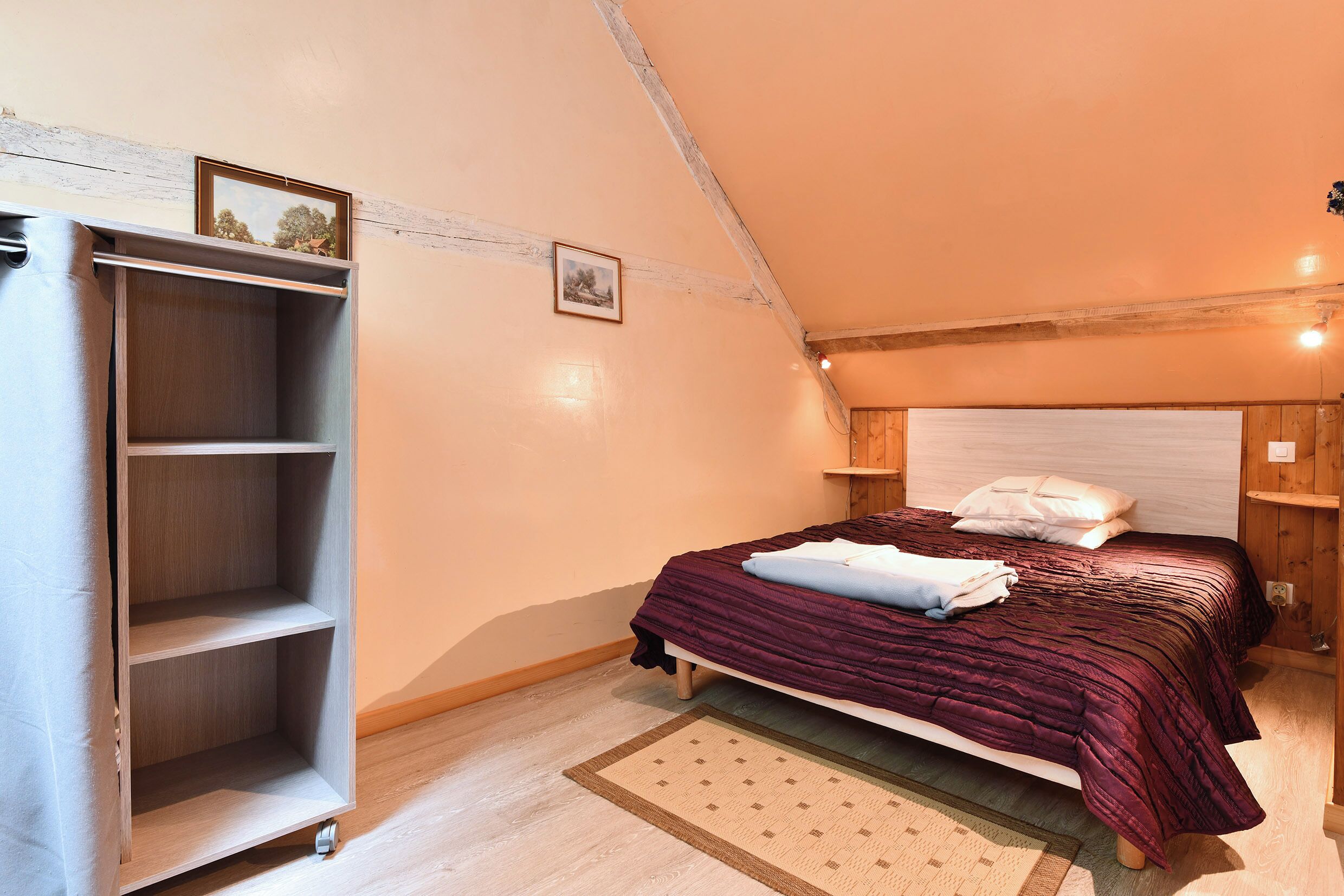 Een slaapkamer met een bed, een kledingkast en een kleed.