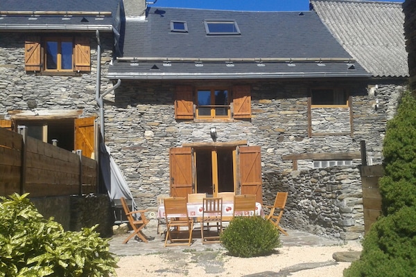 La façade sud de la maison avec la grande terrasse et une partie du jardin