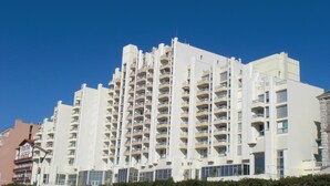 A multi-story hotel with balconies on each floor, a flat roof, and a clear blue sky in the background. - Apart 4 pers. with swimming pool and unbelievable view on ocean ! (Biarritz)